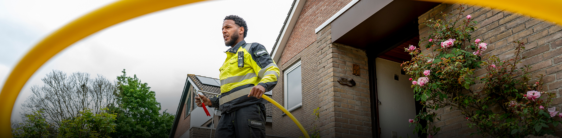 Monteur Stedin loop buiten voor huis met gele kabel