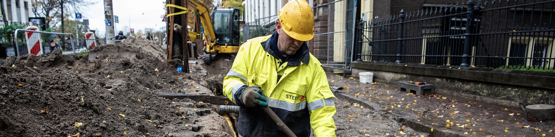 Monteur in opengebroken straat aan het werk