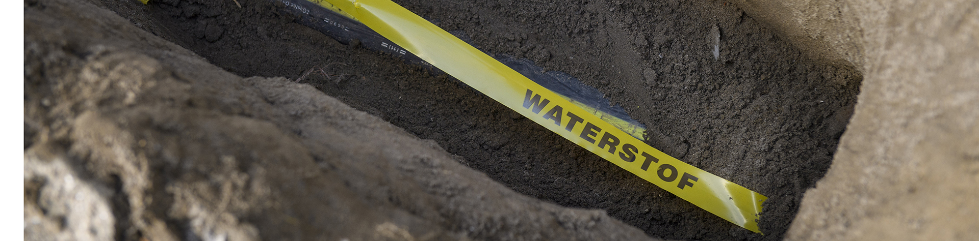 Een geul in de grond met op de bodem een geel link met waterstof erop geprint