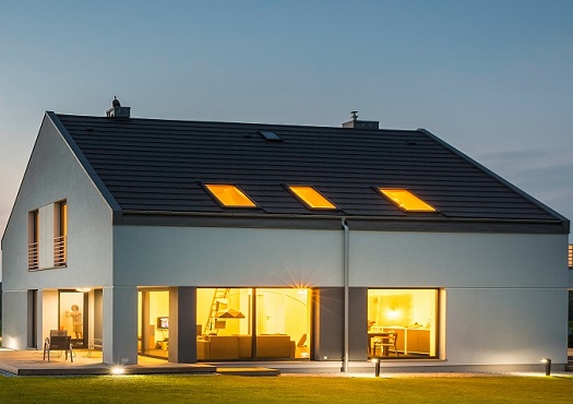 Vrijstaande woning met verlichting aan bij zonsondergang