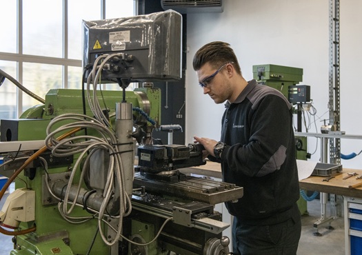 Man aan het werk bij productiemachine