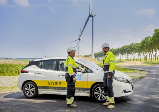 Monteurs bij windmolenpark op achtergrond