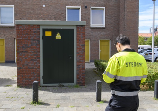 Stedin monteur bij transformatorhuisje in een woonwijk