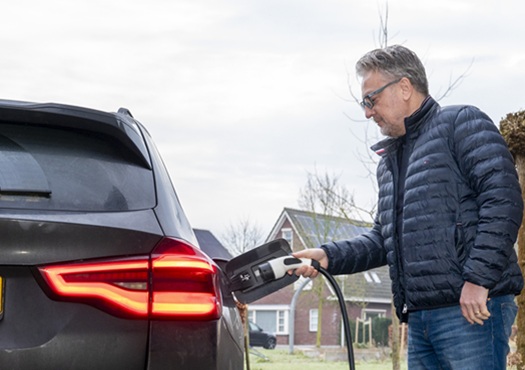 Laadpaal thuis Man steekt stekker in auto