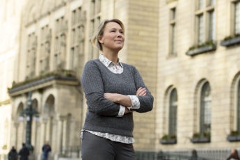 Ambtenaar met armen over elkaar voor het gemeentegebouw