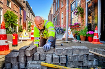 Stedin-monteur brengt bestrating aan