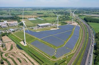 Park met zonnepanelen langs een snelweg met tussen de panelen 3 windmolens