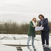 Man en vrouw bekijken tussen de zonnepanelen documentatie