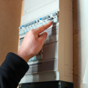Monteur wijst met zijn hand naar de meterkast