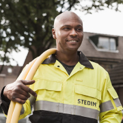 Stedin monteur loopt met kabels over zijn schouder