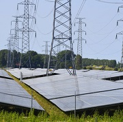 Zonnepark met hoogspanningsmasten op de achtergrond
