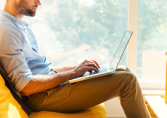 Man werkt met laptop op schoot