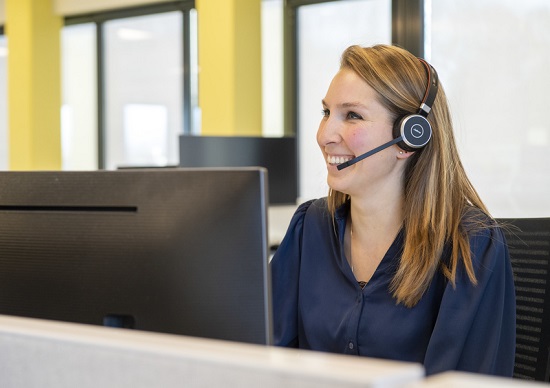 Medewerkster Stedin met headset achter de computer