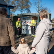 Stel met kind kijken naar elektriciteitshuisje